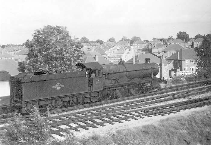 Ex-GWR 4-6-0 Hall class No 5994 'Roydon Hall' is seen at the head of a West Country express as it passes the refuge siding south of Haslucks Green bridge