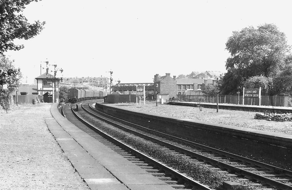 Looking towards Birmingham along the sweep of the Up Main platform, the tail end of a parcels train on the up main line has just past the Soho and Winson Green Signal Box