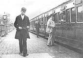 GWR Guard Denstone, wearing his frock coat, walks back to his guard van ready to wave the train off circa 1900