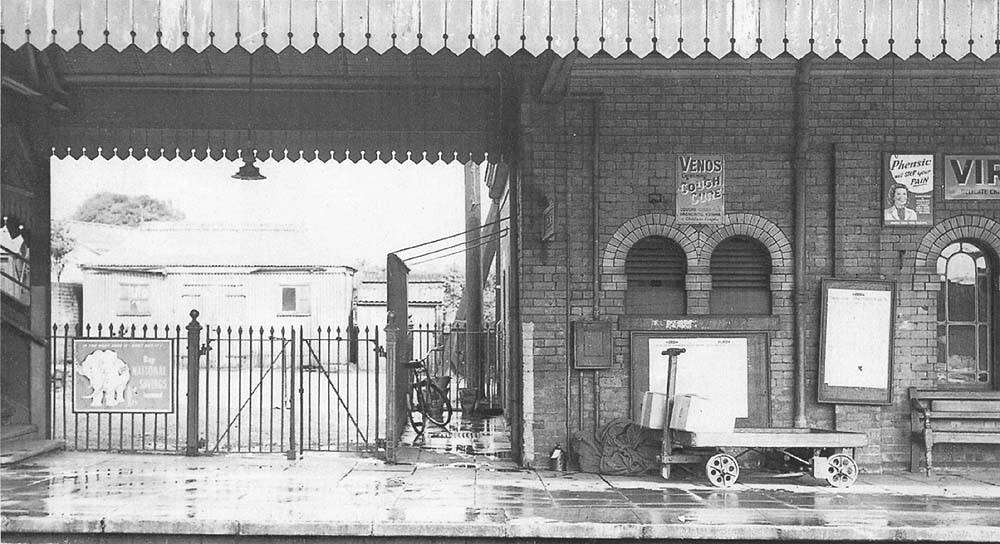 Looking towards platform one from platform two showing the gated access to the main station driveway with a large Pagoda hut seen standing opposite