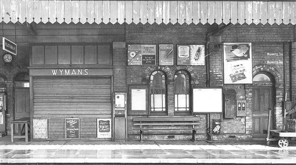 View from Platform 2 of Wymans bookstall with the platform ticket barrier seen to its left and the parcel office doorway seen to the right