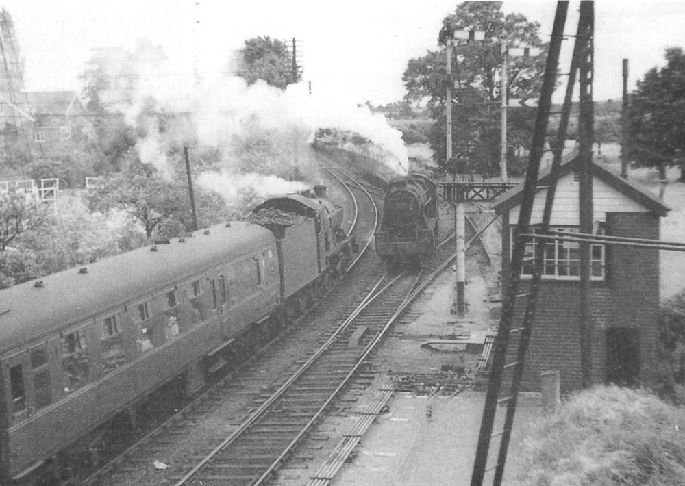 An unidentified ex-GWR 4-6-0 Hall class locomotive is seen passing Stratford on Avon West Signal Box on an express service to Worcester