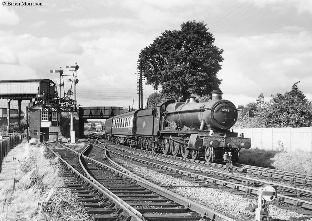 Ex-GWR 4-6-0 Hall class No 4973 'Sweeney Hall' is seen passing Stratford on Avon West Signal Box on a Birmingham to Cardiff and Swansea service