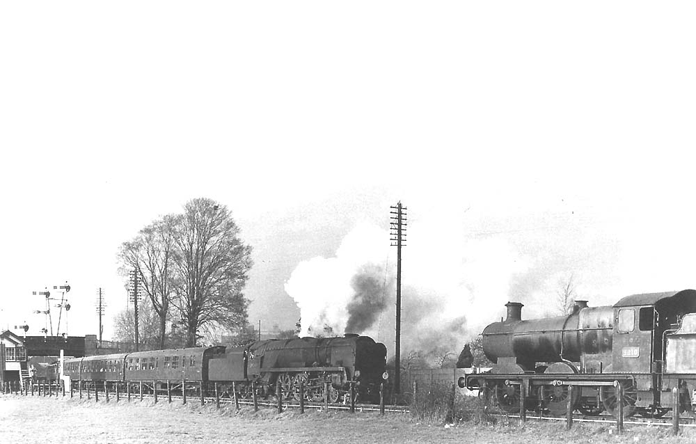 Rebuilt West Country 4-6-2 No 34044 'Woolacombe approaches ex-GWR 0-6-0 No 2210 which is standing in the refuge siding on 14th April 1964