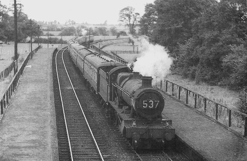 An unidentified ex-GWR 4-6-0 Hall class locomotive is seen at the head of a thirteen-coach Saturdays-only 10:35am Paignton to Wolverhampton service