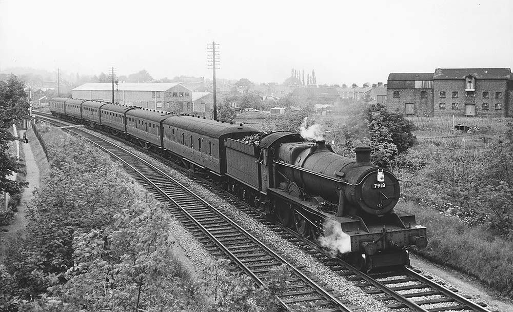 British Railways built 4-6-0 6959 Class No 7918 'Rhose Wood Hall' passes under the former SMJ bridge on 23rd May 1964
