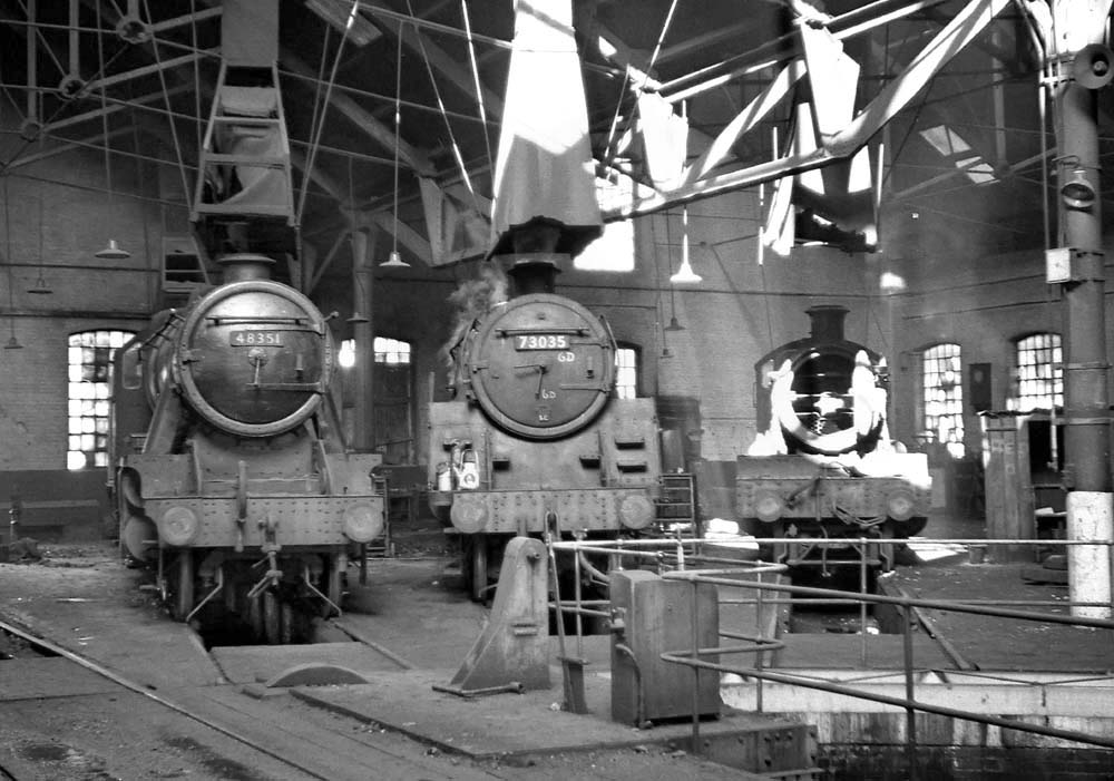 Inside Tyseley shed with three locomotives on view, a BR Standard Class 5MT, an ex-LMS Class 5 and an ex-GWR Manor Class locomotive on 31st January 1965