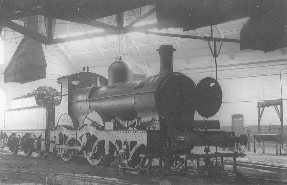 GWR 2-4-0 Barnum class No 3210 an outside-framed locomotive is seen inside one of the roundhouses undergoing repair work on its inside cylinders