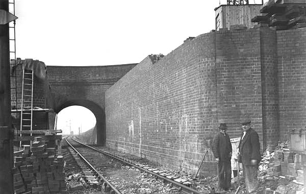 Looking towards Tyseley station as workmen are seen working on building Stockfield Road bridge's new abutment adjacent to the up main line