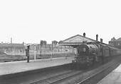 An unidentified ex-GWR 4-6-0 Castle Class class locomotive passes through the station circa 1955