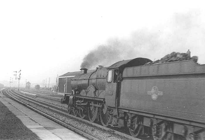 British Railways built 4-6-0 Castle class No 7024 'Powis Castle' is seen passing through Tyseley station on a down express with Tyseley North Signal box in the distance