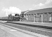 An unidentified ex-GWR 4-6-0 King class locomotive is seen passing through Tyseley station's up main platform with an express service to Paddington