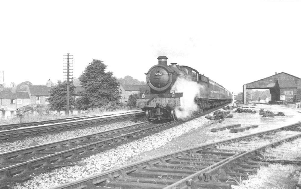 Ex-GWR 49xx Class 4-6-0 No 5912 'Queens Hall' heads an up train past Coventry Road Yard's good shed in 1959