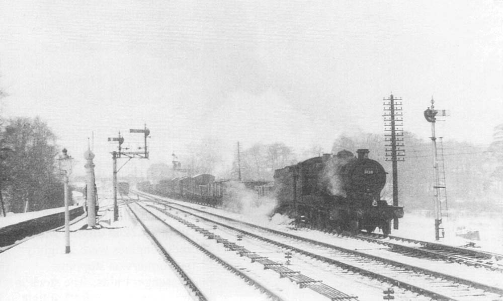 Ex-Great Western Railway 30xx Class 2-8-0 No 3028 stands on the up refuge loop during the Winter of 1955