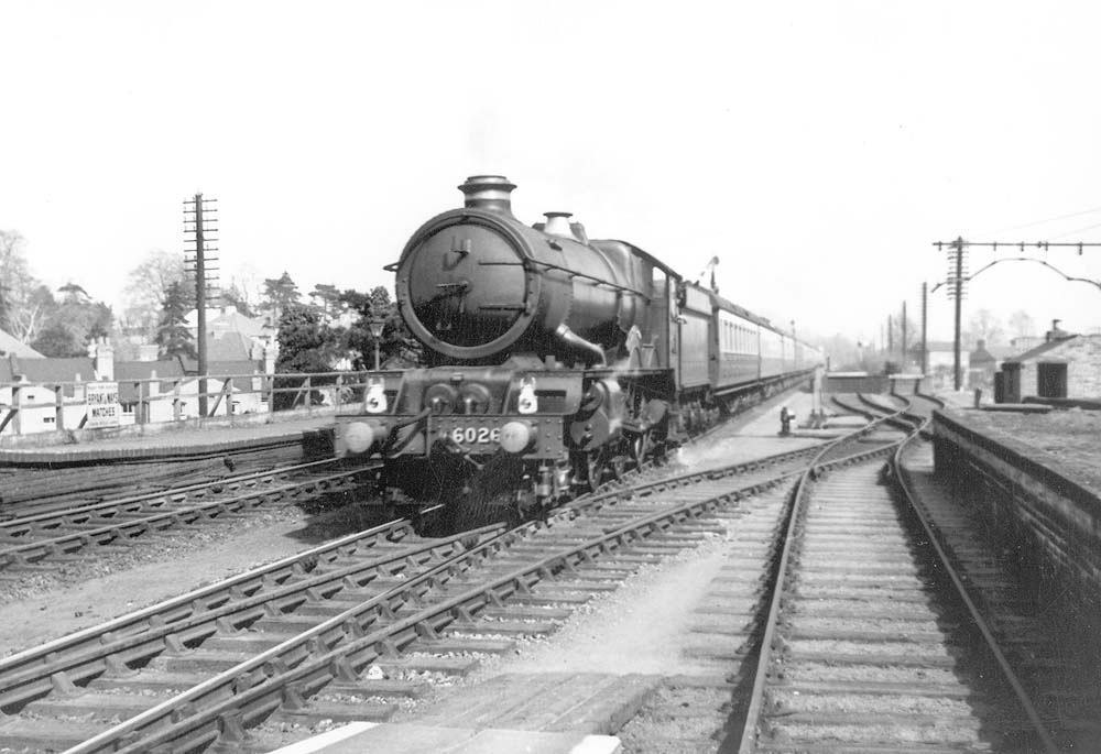 GWR 4-6-0 King class No 6026 'King John' with just a slight evidence of smoke at the chimney roars through the station on a down express service