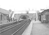 A view looking south showing workmen working on relaying the down platform surface in front of the waiting room
