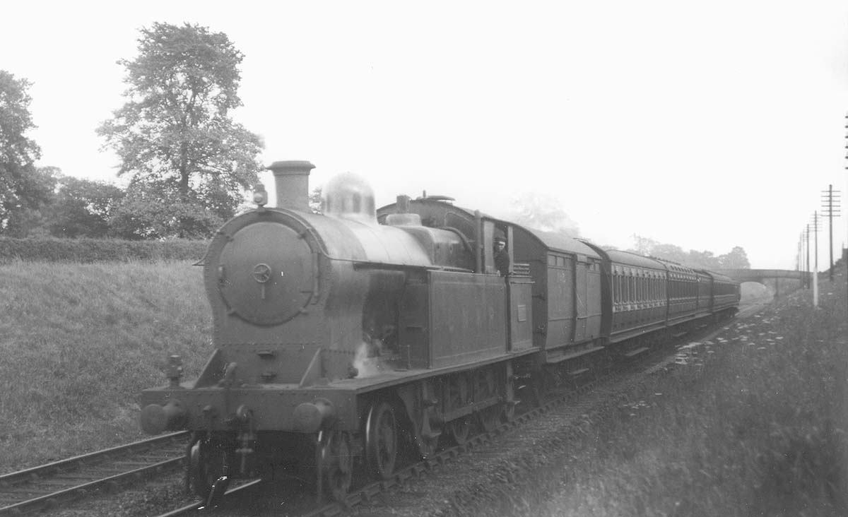 Ex-LNWR 4P 4-6-2T No 2670 is seen still wearing LNWR livery at the head of a local passenger service prior to be renumbered No 6955 by the LMS