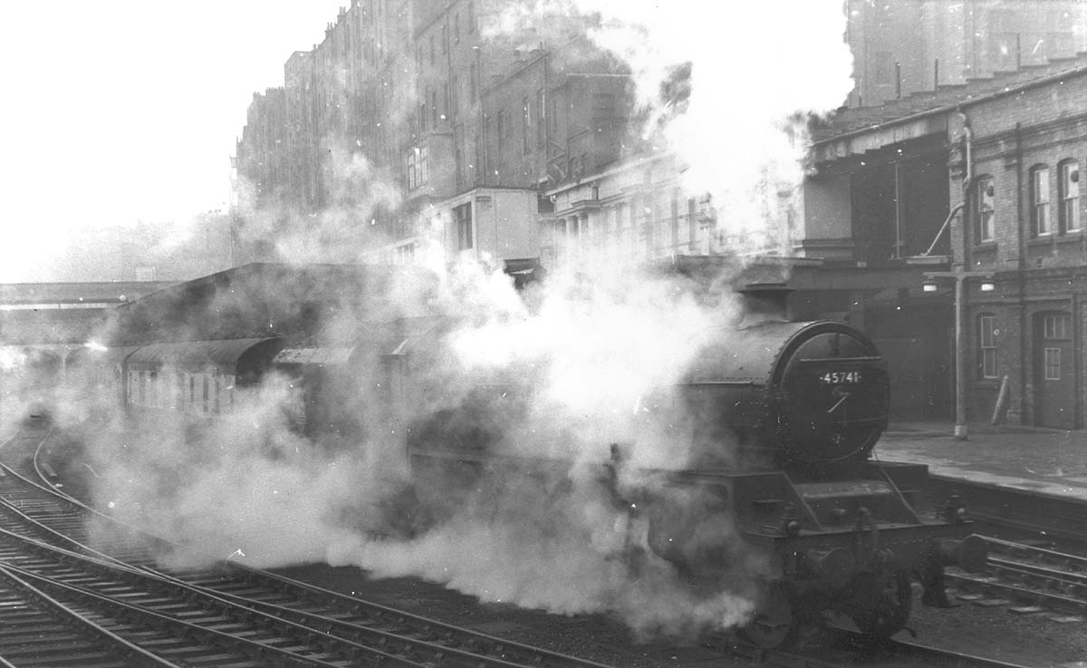 Ex-LMS 5XP 4-6-0 Jubilee class No 45741 'Leinster' is seen smothered in steam on a wet and foggy Spring day as it heads the 10 20am up express service to Euston