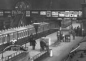 Close up showing passengers standing by the station's Cloak Room on  Platform 3 as the train to Walsall waits to depart