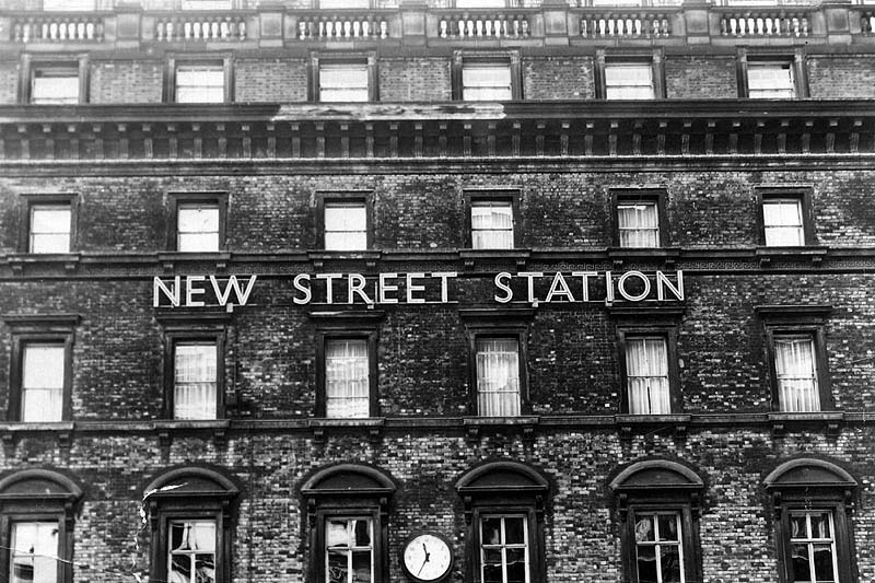 Photograph of New Street Station's sign on the Queens Hotel's facade and and the new clock