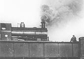 Close up showing the 0-4-0ST which is working hard as it crosses over the bridge at the head of the short train