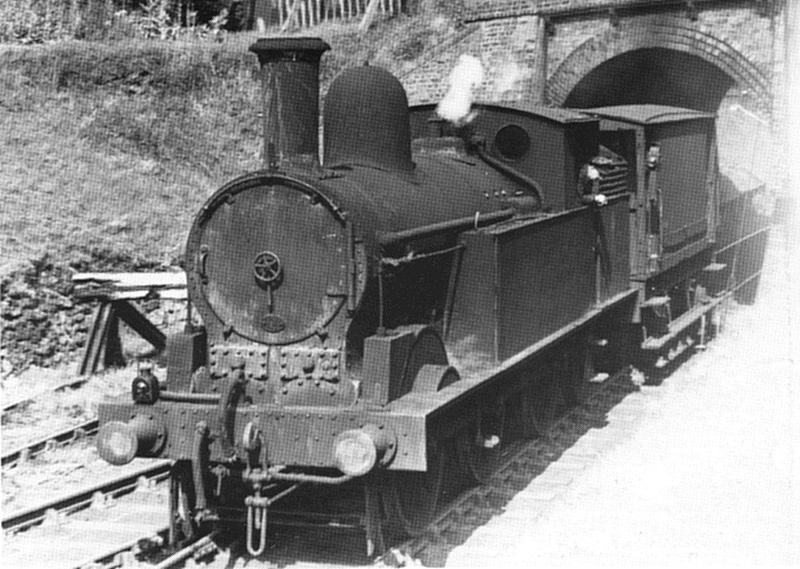 An unidentified ex-LNWR 0-6-0T locomotive is seen with just a goods brake van in tow during the branch's LMS days