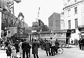 View from the High Street of the two two main trusses over the junction being demolished by a large mobile crane