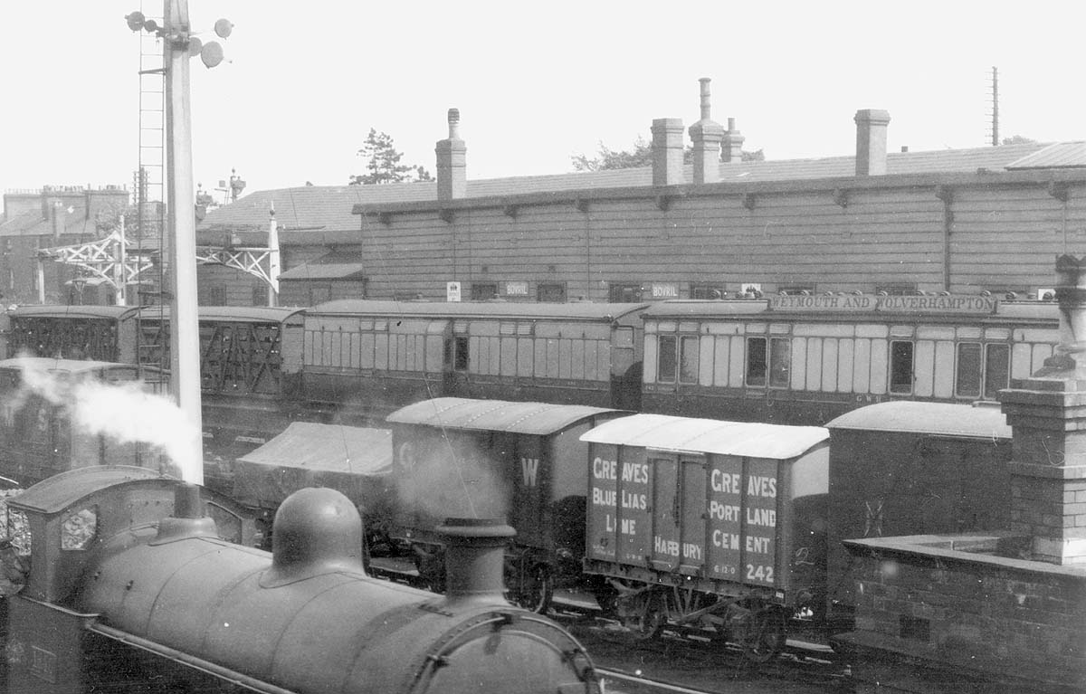 Close up showing Great Western Railway rolling stock passing behind the GWR station on 26th May 1925