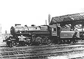 British Railways built 4MT 2-6-0 No 43023 is seen bathed in sunshine outside the part demolished shed