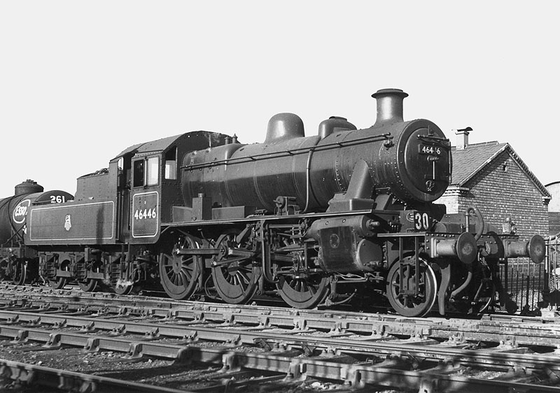 Ex-LMS design 2-6-0 2MT No 46446 is seen at the head of a train of oil tank wagons in Nuneaton's marshalling yard