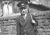 'Bill 'Jock' Bailey stands with lamp in hand in his guard's uniform at the rear of No 7 New Station cottage