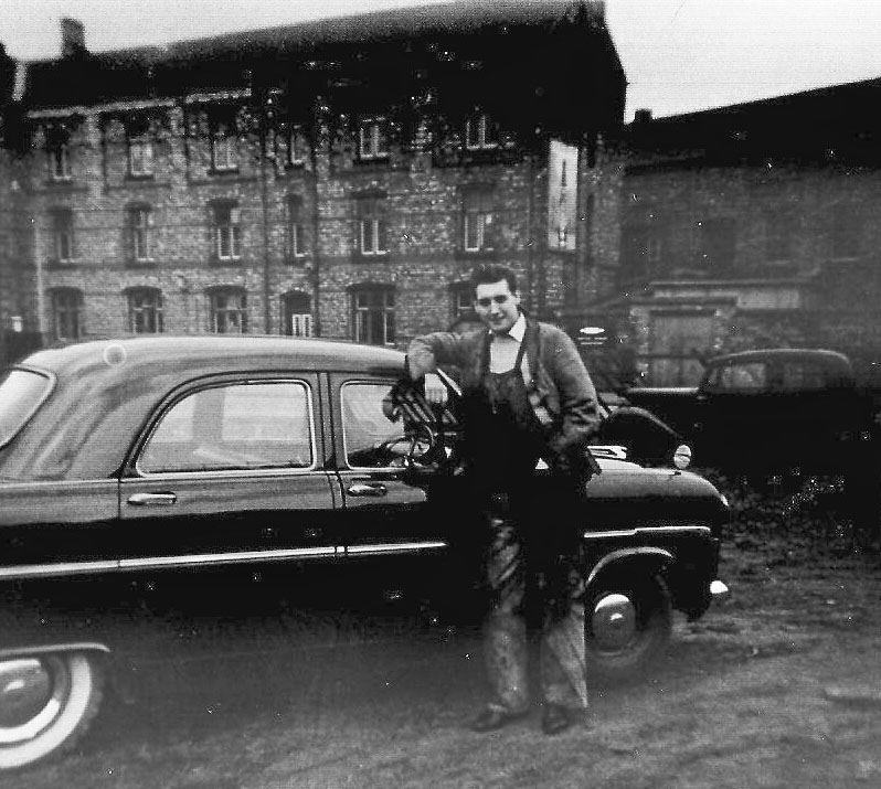 Fireman Bill 'Waterloo Willy' Warriner poses next to his mates new Ford Consul in front of Rugby Enginemen's Lodge