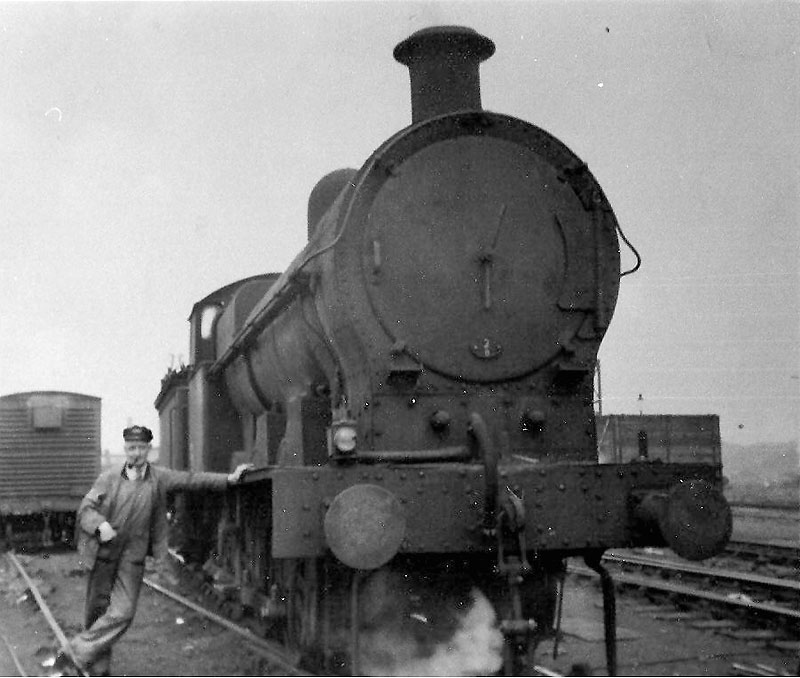 An unknown driver poses for the camera alongside of an unidentified ex-LNWR G2a 0-8-0 locomotive