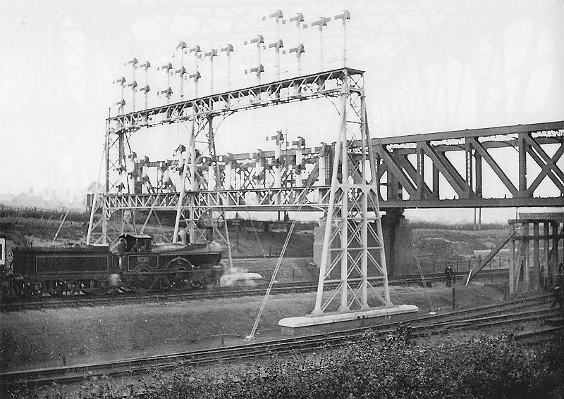 View of an unidentified LNWR 2-4-0 'Big Jumbo' class locomotive held by the signals under the GC bridge