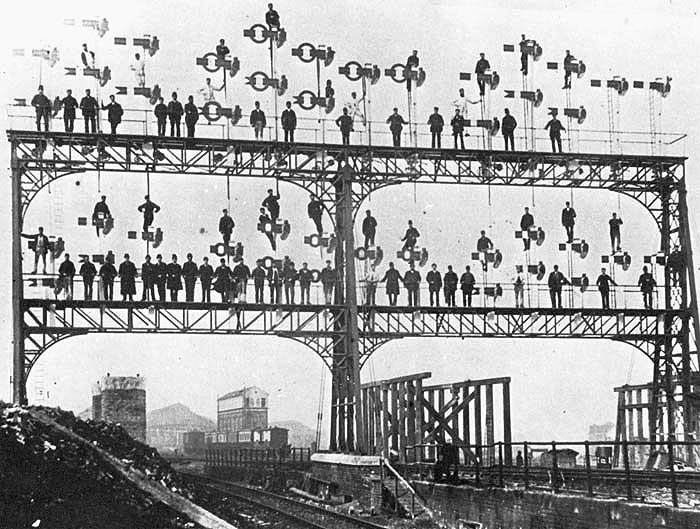 A publicity photograph by the LNWR of their staff and men standing on the LNWR Signal Gantry prior to the GC bridge being erected