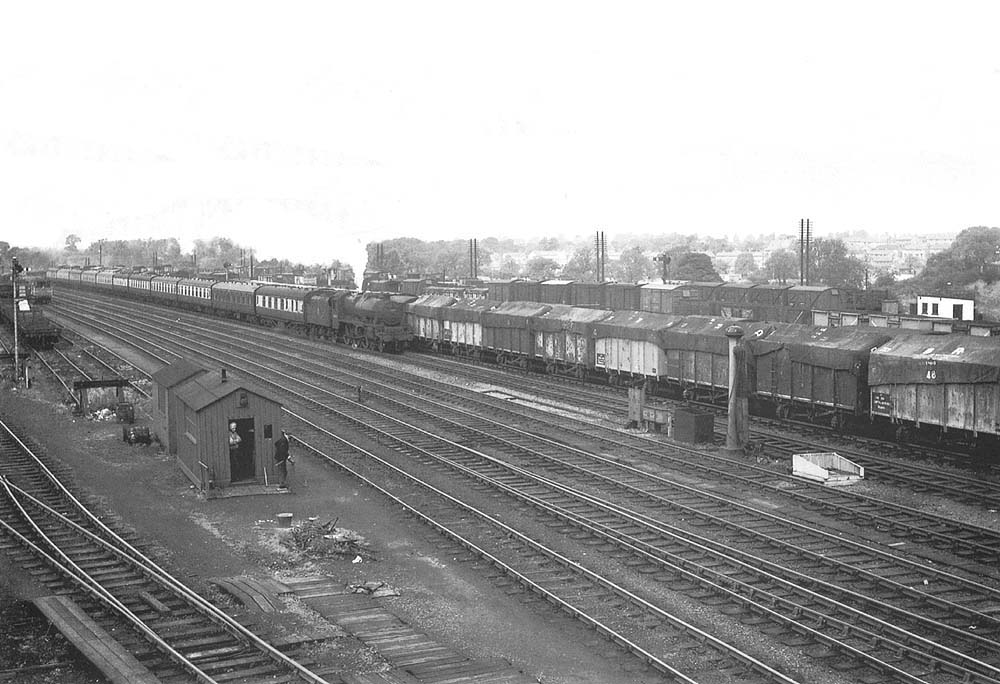 View from the wooden bridge of an unidentified ex-LMS 4-6-0 Jubilee class locomotive at the head of an up express passing Rugby's up exchange sidings