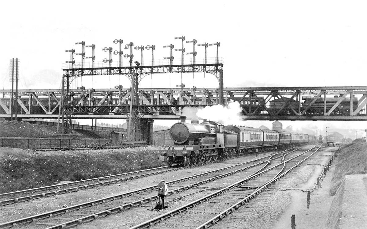 An unidentified LNWR 4-6-0 Claughton Class locomotive heads an up express to Euston beneath the GCR bridge