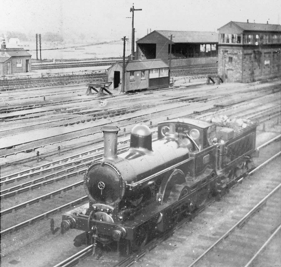 LNWR 2-2-2-0 No 410 'City of London', a three cylinder compound locomotive is seen in front of Rugby No 5 Signal Cabin