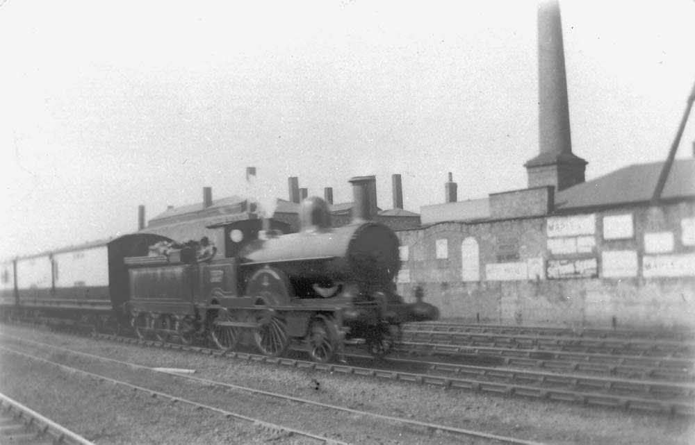 LNWR 2-4-0 No 1217 'Florence' passes through Rugby with an up express with the MR shed in the background