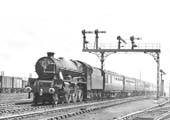 LMS 4-6-0 No 5552 'Silver Jubilee' at the head of a down express near the goods yard as it approaches the station