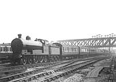 An unidentified LNWR 4-6-0 Prince of Wales class locomotive is seen entering the station on a down express as it passes under the GC bridge