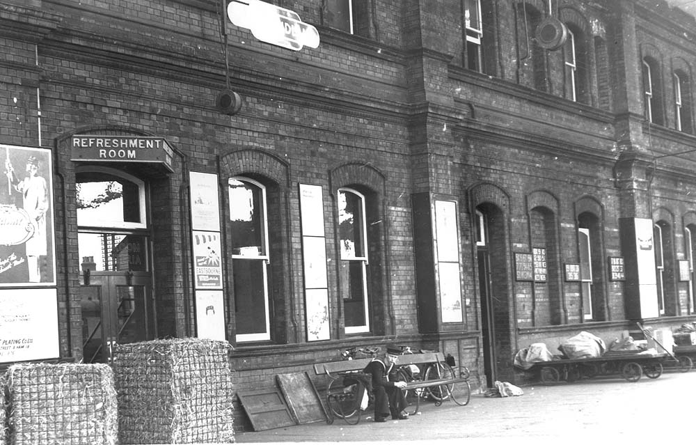 View of the entrance to the refreshment room from the up platform showing mail bags loaded on trolleys on 13th April 1954