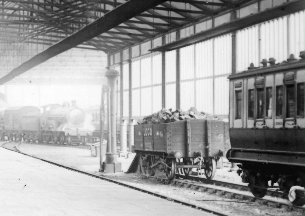 Close up showing a LNWR 4-4-0 at the head of an express using the scissor crossing to exit the southern section of the down platform