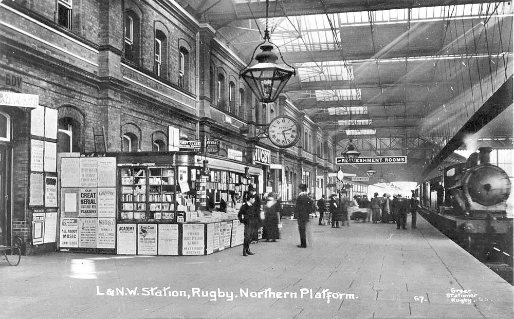 A post May 1915 view of Rugby station's down platform as a LNWR train for Euston arrives opposite the newsstand