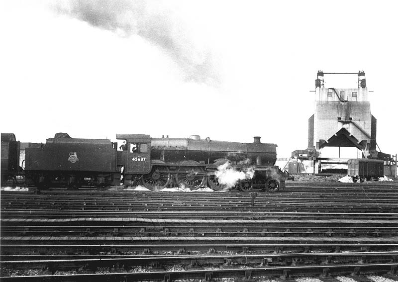 Ex-LMS 4-6-0 Jubilee class No 45637 'Windward Islands' at the head of an up express passes Rugby's coaling tower
