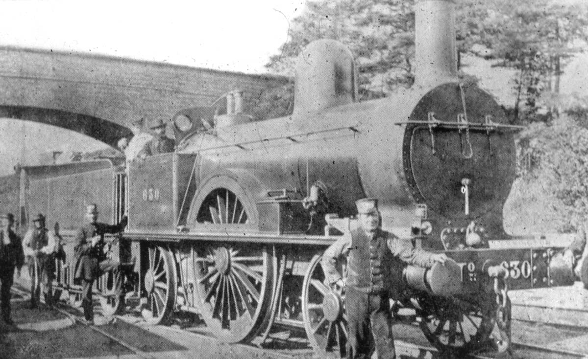 View of LNWR 2-2-2 'Bloomer' No 630 is standing just north of the original Warwick terminal station with sidings in the background