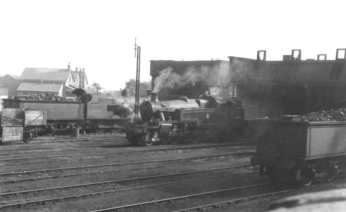 Ex-LNWR 7F 0-8-0 'G2a' No 49120 and ex-LMS 3MT 2-6-2T No 40076 are both seen in steam standing on shed on 28th September 1956