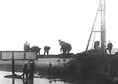 Close up showing a group of Midland Railway officials inspecting the eroded bank of the River Arrow as a gang attempt to repair the bridge