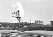 An unidentified ex-LMS 8F 2-8-0 locomotive reverses out of Saltley shed and over Duddeston Road during the early 1960s
