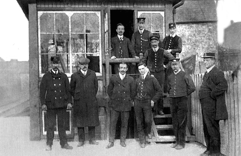 Members of staff from Kings Heath station pose on and in front of the steps to the signal box circa 1920